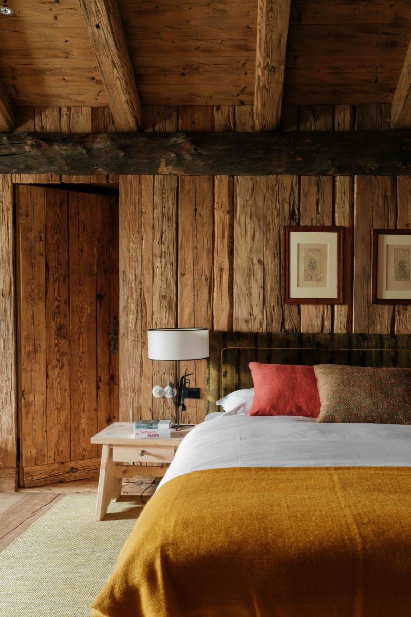 A Swiss style luxury hotel bedroom with a large bed and wooden clad walls.